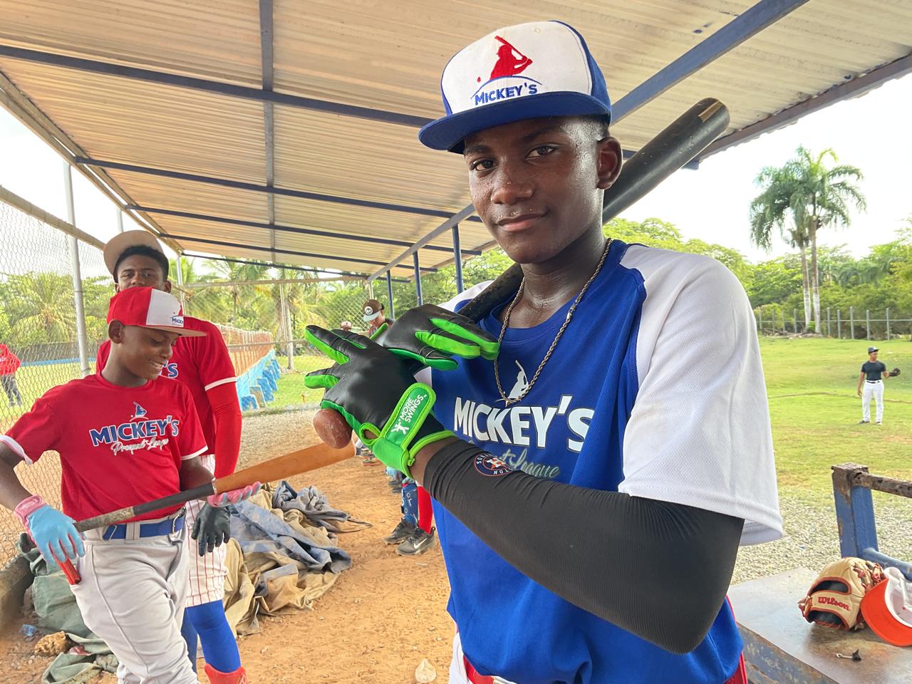 Dominican baseball player showing More Swings batting gloves