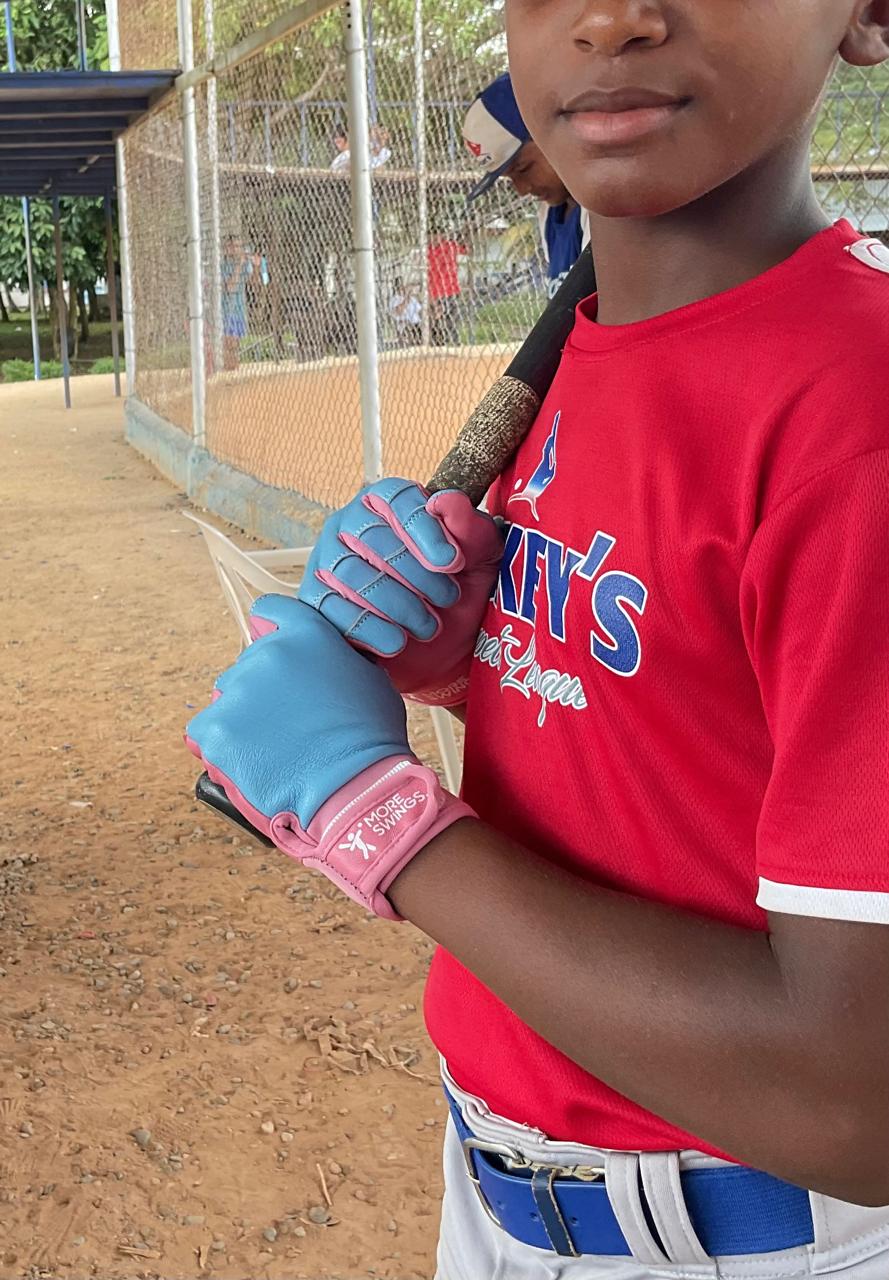 Young Dominican baseball player wearing More Swings batting gloves